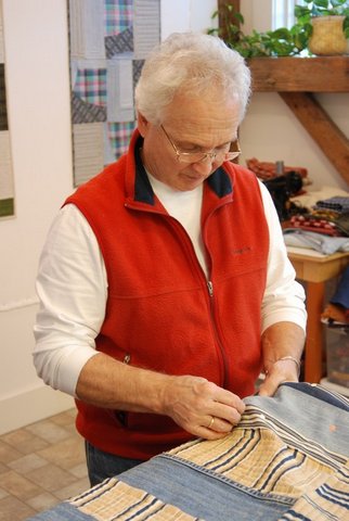 Roy quilting with worn Levi's