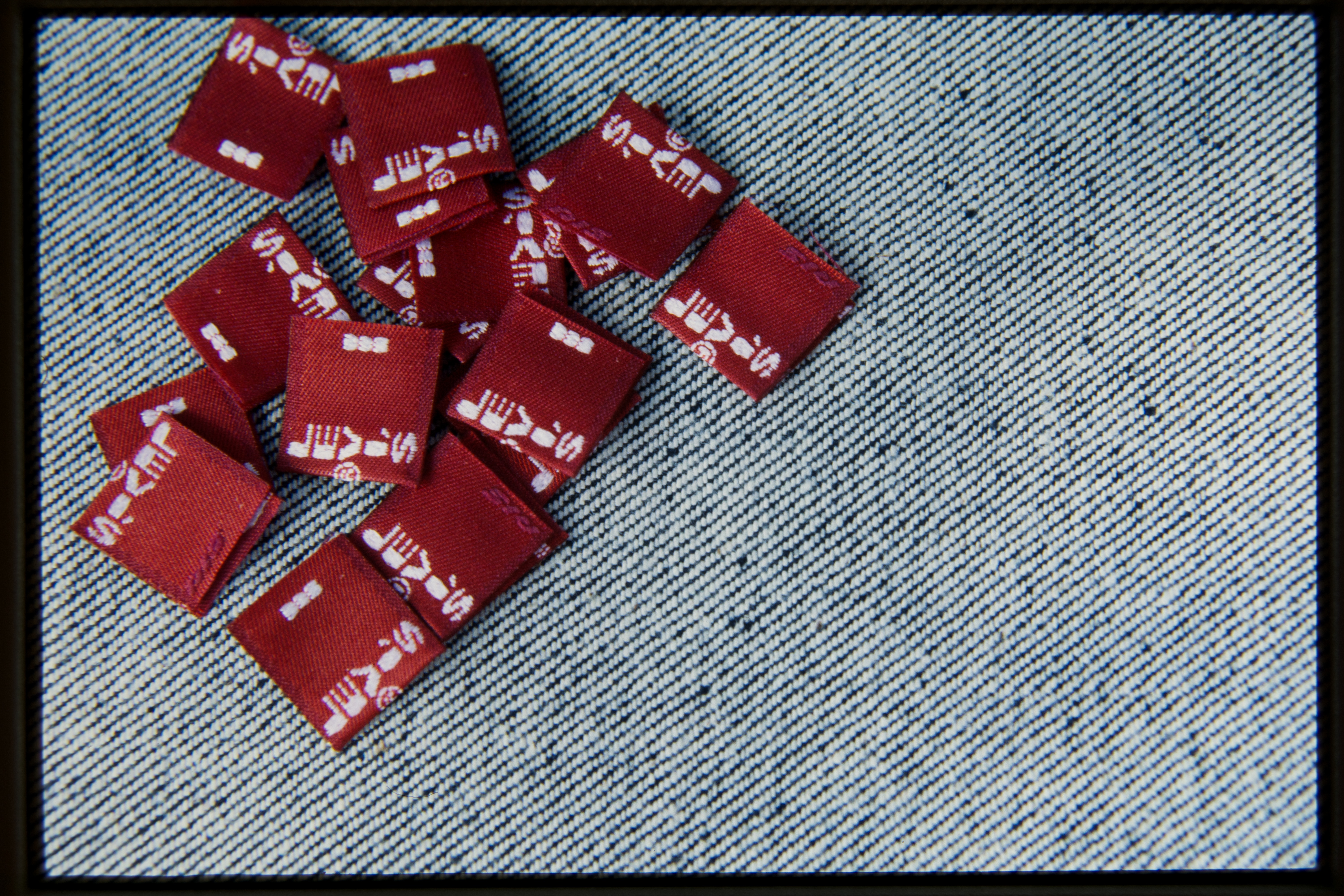 a pile of Levi's® red tabs sit on a denim canvas.