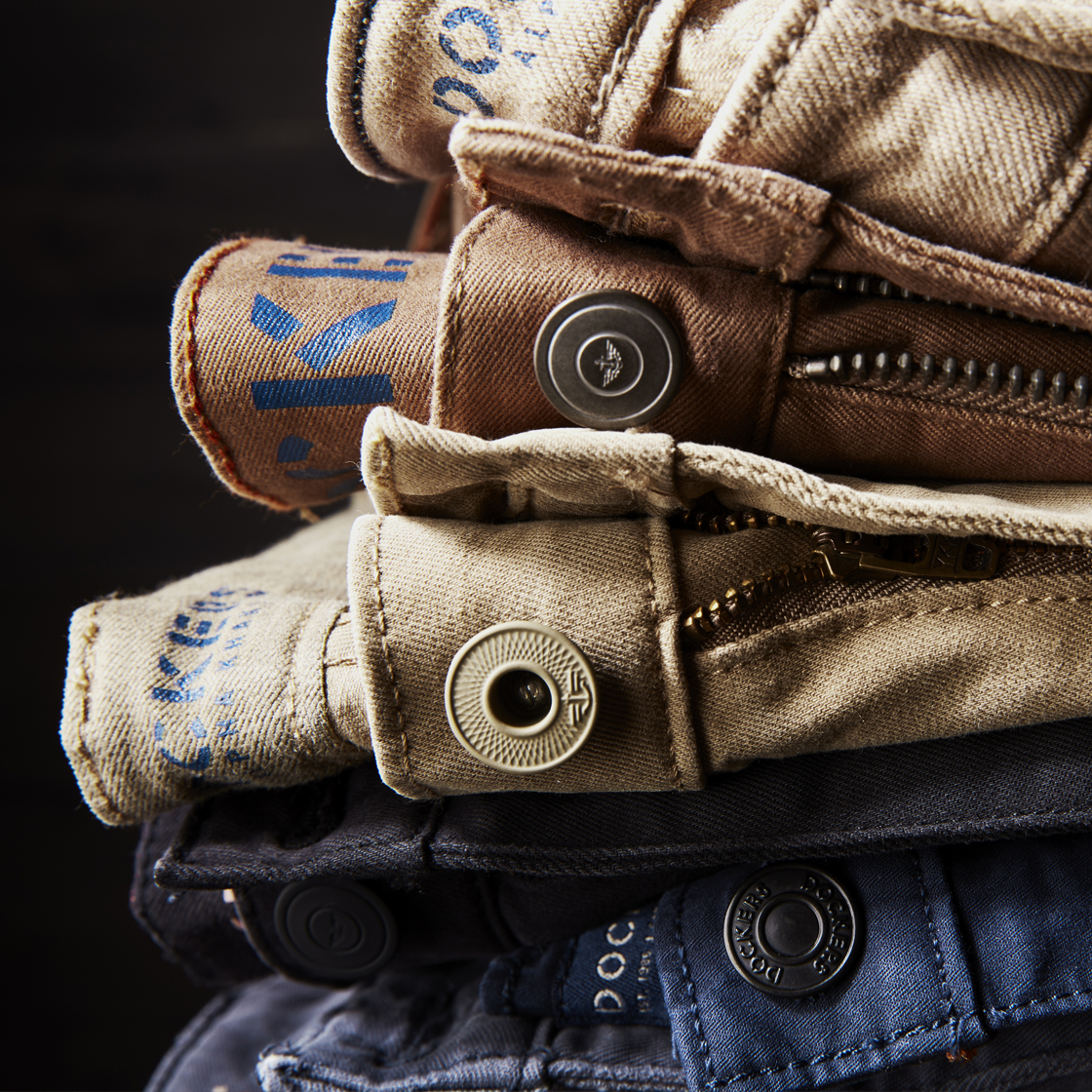 A pile of stacked Dockers® pants, cropped in on the front river and zipper fly.