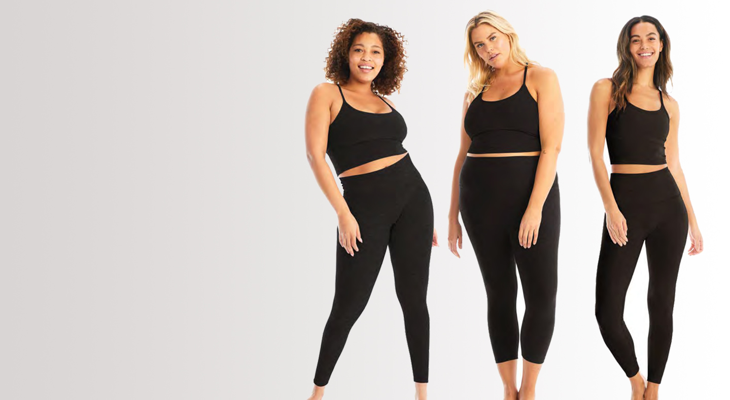 Three models pose wearing black Beyond Yoga® tank tops and leggings.