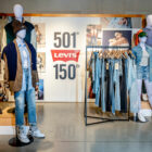 The interior of a Levi's® store showcasing mannequins and hanging displays of Levi's® 501® products. A sign reads 501® Levi's® 150th.