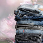 A stack of folded Levi's® denim jean sin various washes with a washed out floral background