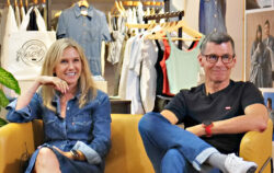 Michelle Gass and Chip Bergh smile while sitting on a couch.