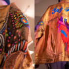 Left: the sleeve of a custom Trucker jacket designed for LS&Co.'s annual Seen & Heard women's summit. Right: a photo of the back of the jacket. The jacket is gold and features a painting of a heart on the back.