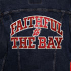 The back of a Levi's® x San Francisco 49ers jacket, reading "Faithful to the Bay" in all caps and red lettering.