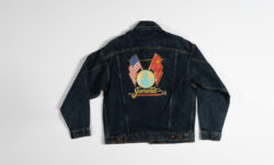 The back of a custom Levi's® Trucker jacket painted by Terry Pearce, featuring flags and a globe.