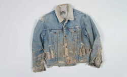 A very distressed and torn Levi's® light-wash denim Trucker jacket with a sherpa collar. 