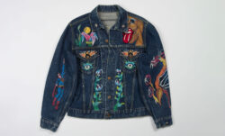 A dark wash Levi's® Trucker jacket painted with colorful floral details. 