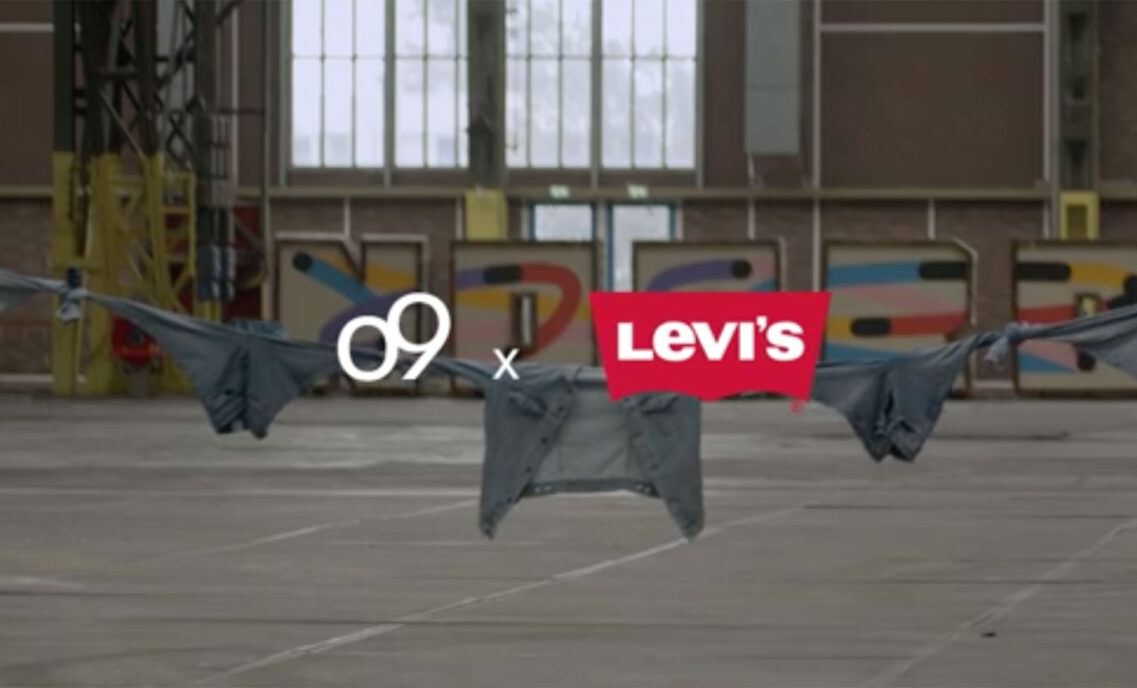 a white o9 logo x a red Levi's® logo are imposed over a photo of various Levi's® denim tied together as a rope and held up in an industrial warehouse.