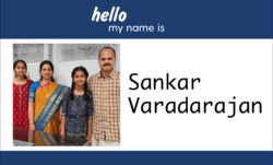 A name badge design. A blue header reads "hello my name is." Below, an image of Sankar Varadarajan and family next to "Sankar Varadarajan" in black script.