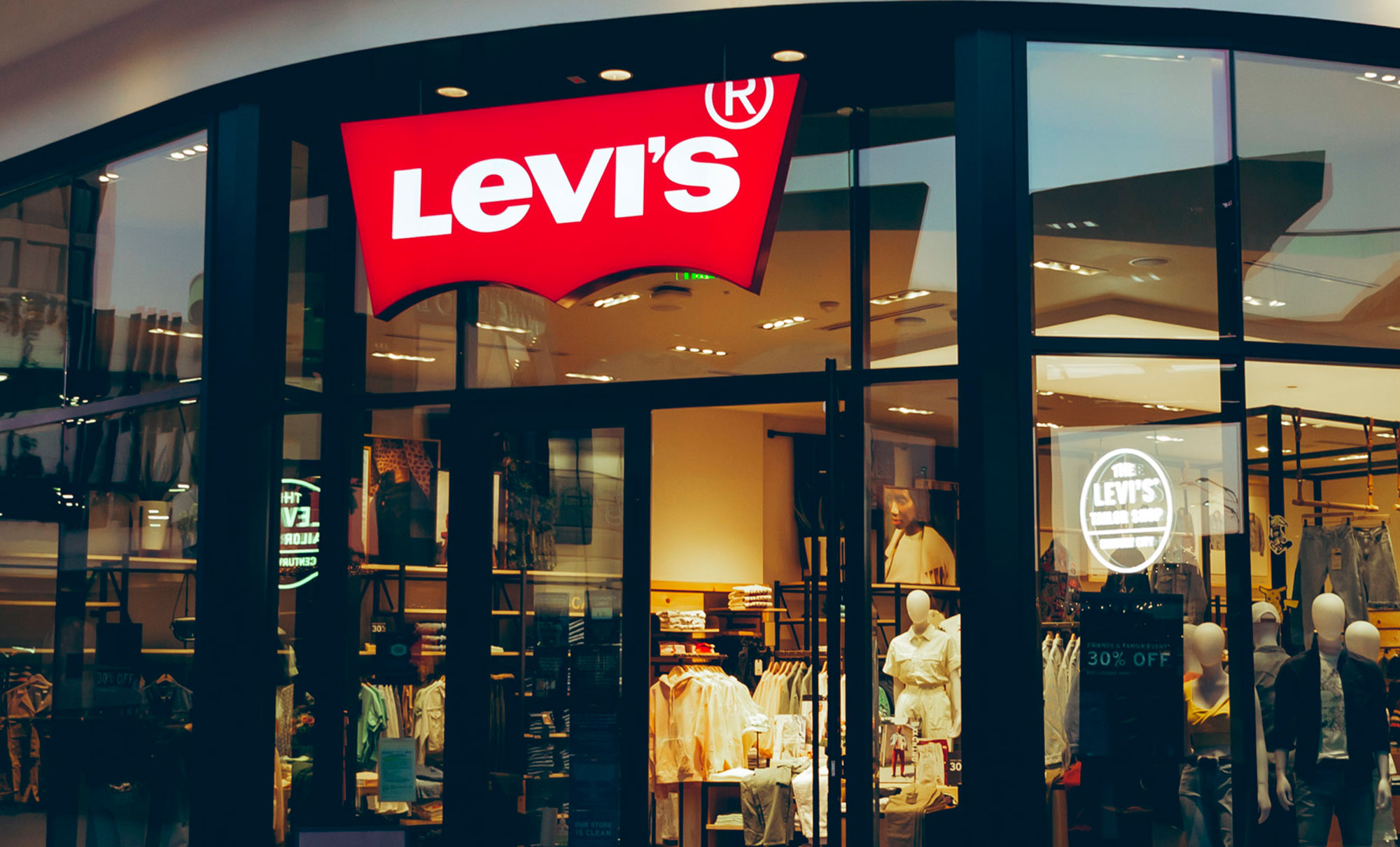 The exterior of Levi's® Century City, featuring a Levi's® logo sign on the top of the front door, opening to products inside.