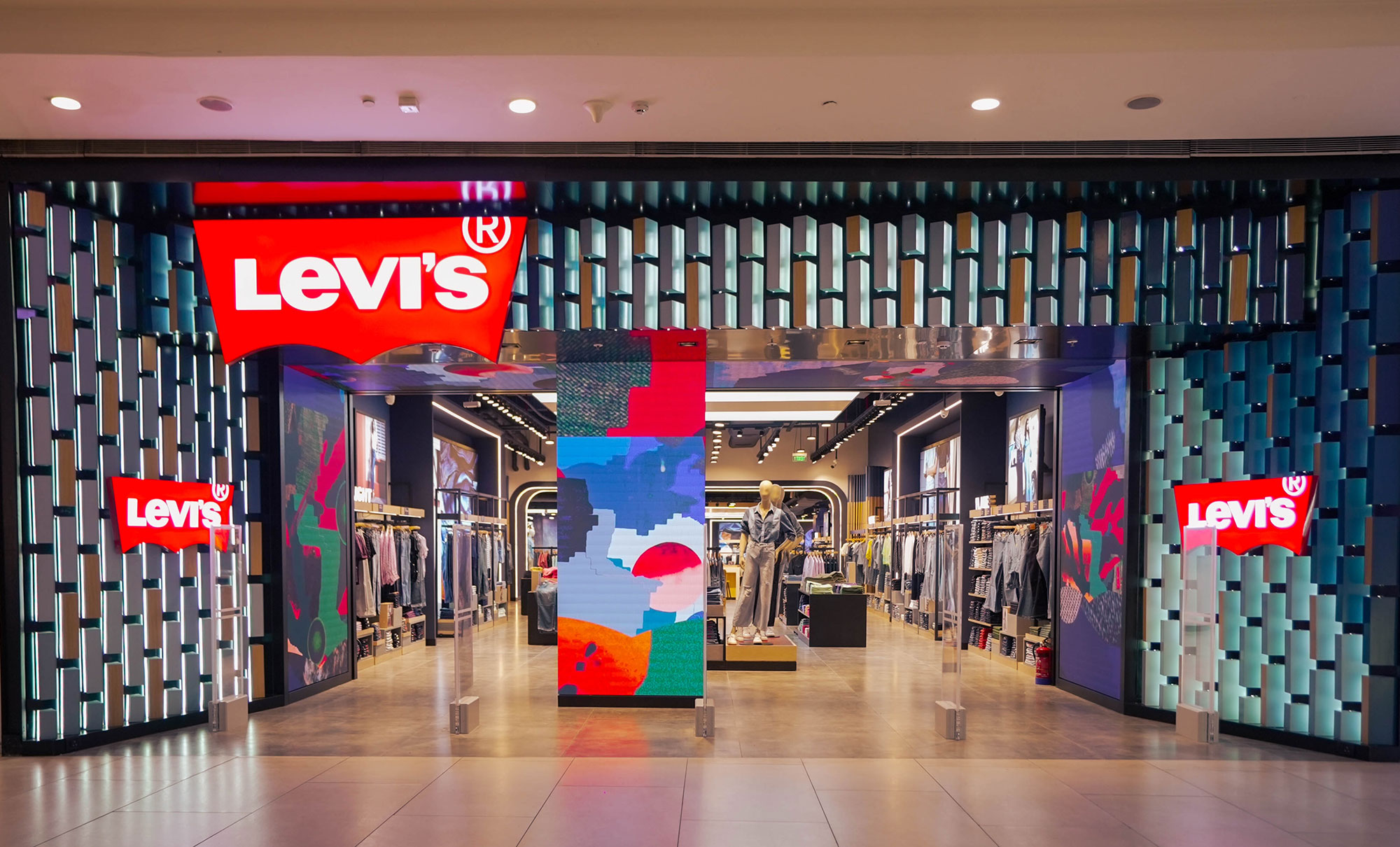 The entrance to the Levi's® store in Pacific Mall in Tagore Garden, New Dehli, featuring a large Levi's® logo above an entrance opening into an LED animation screen and assorted products.