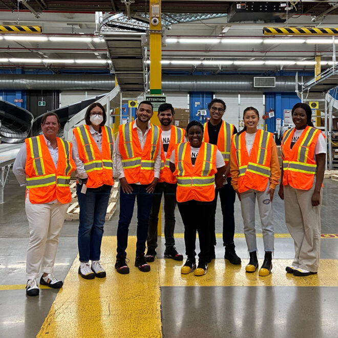 A group of LS&Co. interns wearing high-vis vests touring a Levi's® distribution center