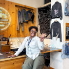 Levi's® Store Manager Gladys Jennings smiles and shows a peace sign while sitting at the Levi's® Williamsburg Tailor Shop.