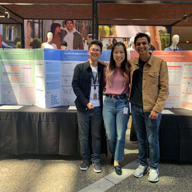 three interns standing in front of a table with their presentation posters