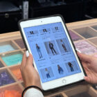 A person's hands hold a tablet featuring a grid of Levi's® products on models with product names and information.