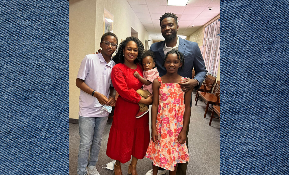 LS&Co. VP of U.S. Retail, U.S. Canada Operations and Real Estate Andre Graham poses with wife and three children. Photo is laid on top of a denim texture background.