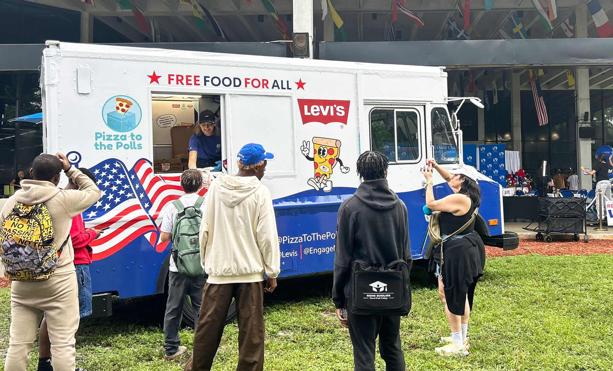 Community college students stand in line to receive free pizza at a "Pizza to the Polls" food truck