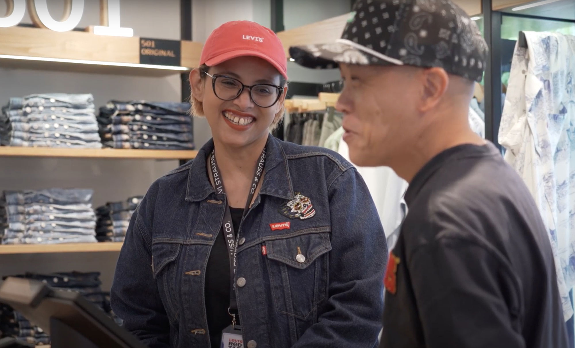 Levi’s® senior stylist Siti Fadillah stands in a Levi's® store and smiles at another employee