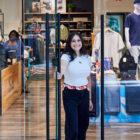 A Levi's® store employee opens the front door of a Levi's® store and smiles at the camera