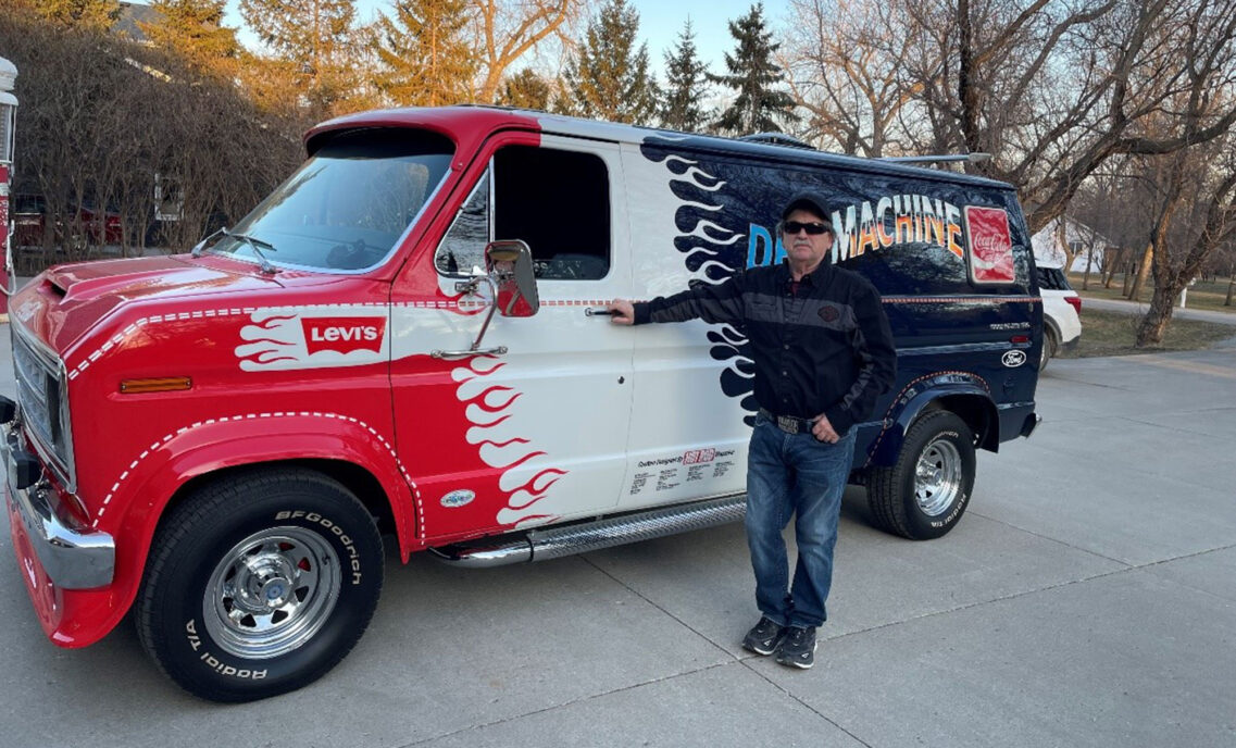 Dann Grinsteiner poses next to his restored "Denim Machine," a red, white and blue Ford van with a Levi's® logo by the driver window and the word "DenimMachine" across the back next to a Coca Cola logo