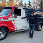 Dann Grinsteiner poses next to his restored "Denim Machine," a red, white and blue Ford van with a Levi's® logo by the driver window and the word "DenimMachine" across the back next to a Coca Cola logo