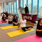 Eight LS&Co. employees pose on their yoga mats as they get ready for a group yoga class to support the 2024 (Run) for Red Tab