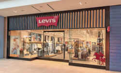 The exterior of the Levi's® Midtown store in Saskatoon, Saskatchewan, Canada. Images of Beyoncé from the Beyoncé x Levi's® REIIMAGINE campaign can be seen in the front window display, and a red Levi's® batwing logo sits atop the front door.