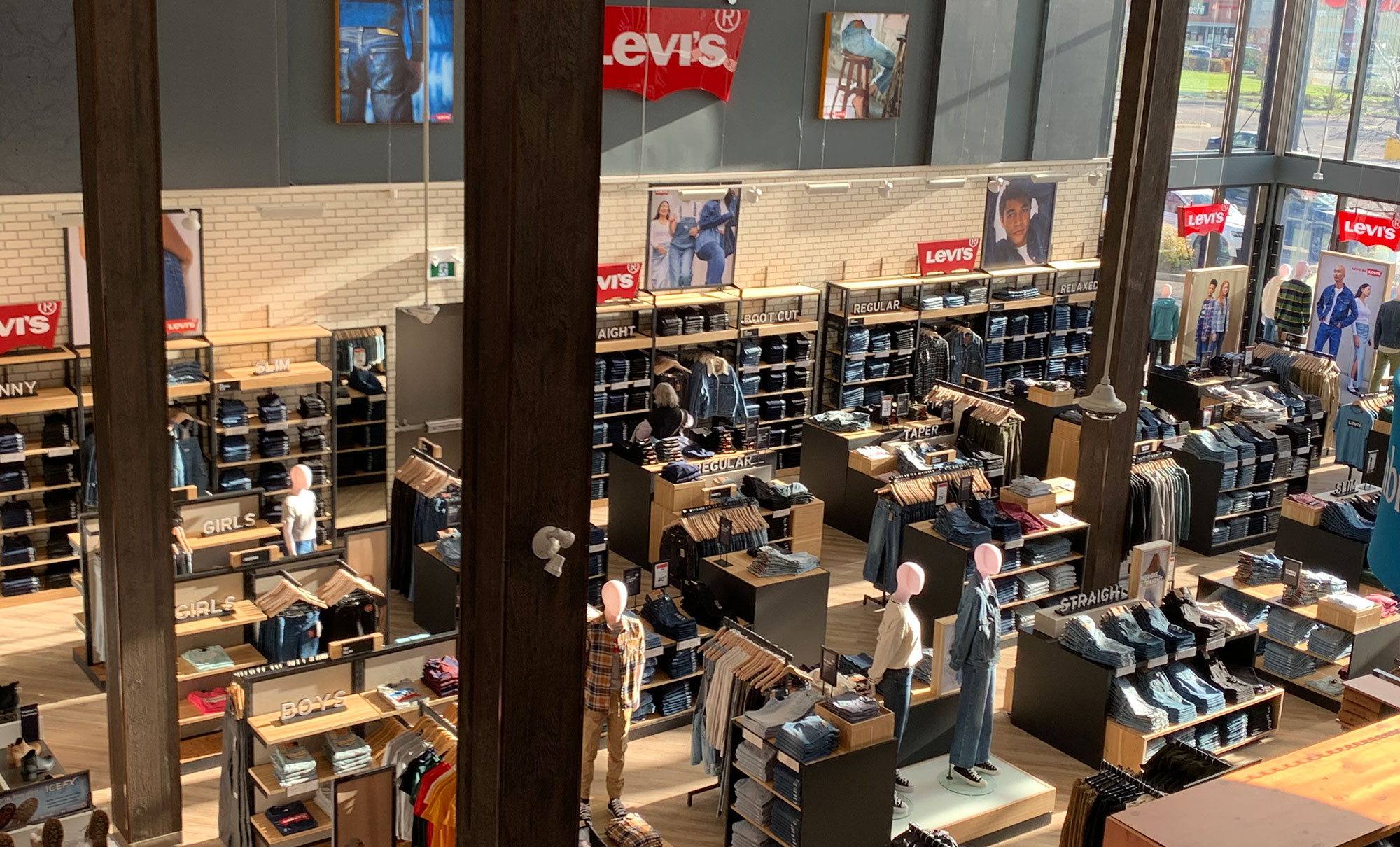 A photo taken from an upper perspective looking down into a Levi's® store, featuring shelves of jeans and product displays