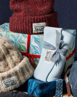 A Levi's® beanie sits on top of a wrapped gift. Other Levi's® beanies lean on top of the gift.