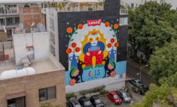 A colorful mural in Mexico City local artist Alee Baes in collaboration with Levi's® for Día de los Muertos, featuring the Levi's® logo, bright red and orange flowers, and a calavera skeleton design