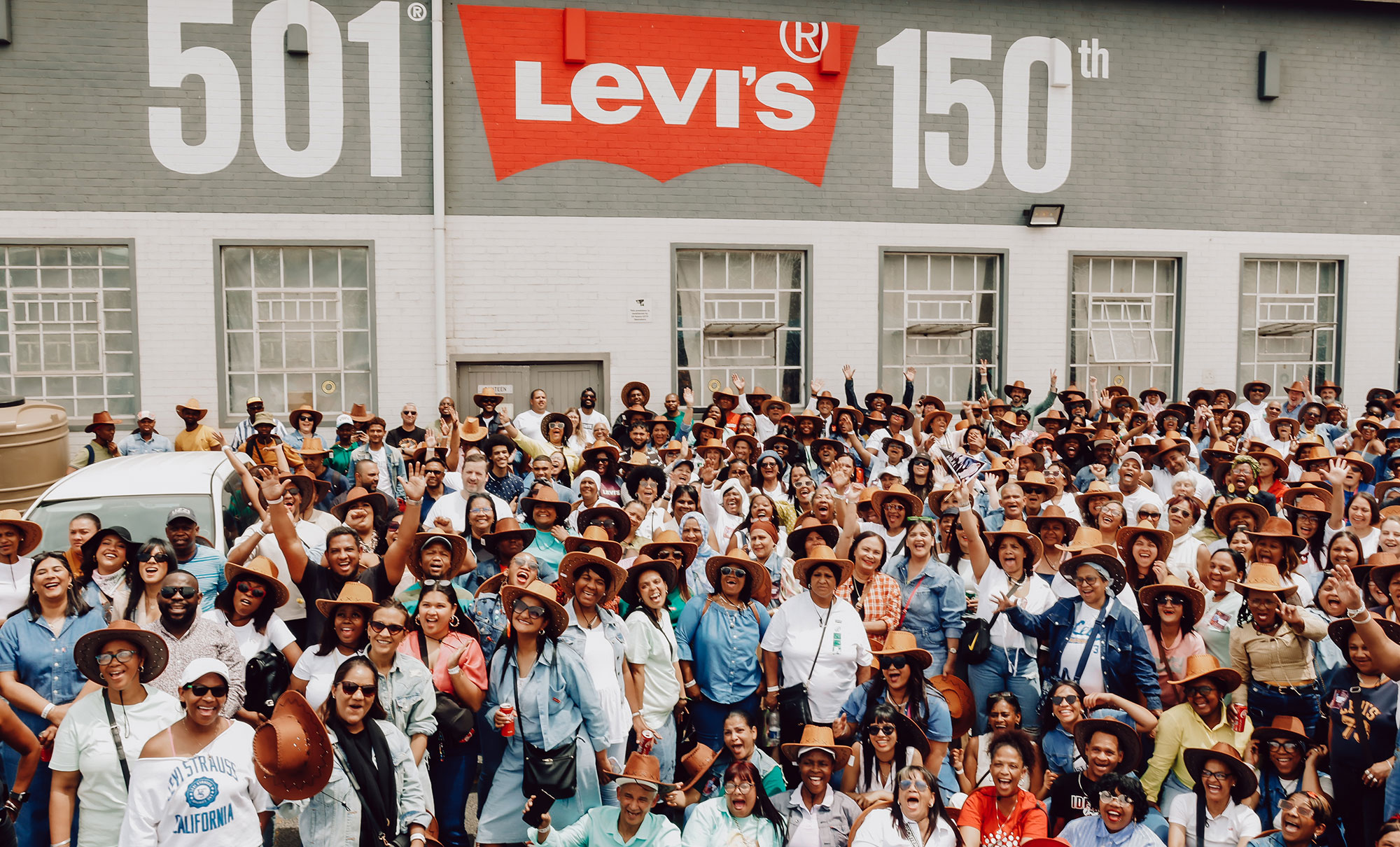 A large group shot of LS&Co. employees in South Africa in front of a sign reading 501 Levi's 150th