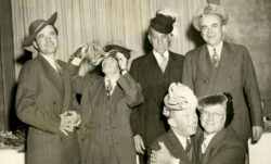 A black and white image of six LS&Co. employees, including first vice president Dan Koshland, posing in costume hats at a retirement party.