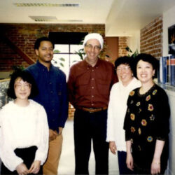 Former LS&Co. CEO Bob Haas wears a Santa had and poses with former LS&Co. employees in the LS&Co. office