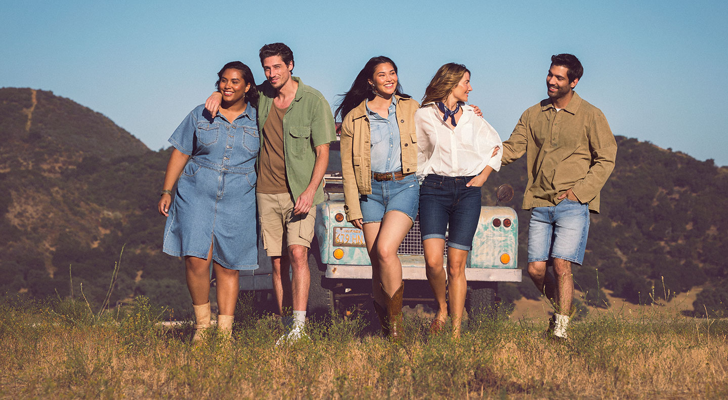 Five people stand in a field and lean on a pick up truck linking arms and wearing Levi Strauss Signature clothing