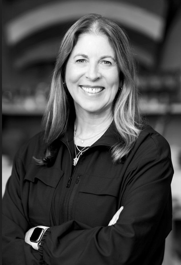 A black and white photo of Nancy Green smiling at the camera with her arms crossed